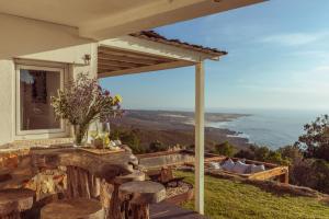 a patio with a table and chairs and a view of the ocean at Wanted Nature House in Azoia