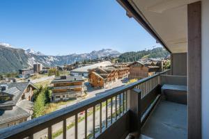 a balcony with a view of a town and mountains at Apartment Itauba Courchevel 1850 - by EMERALD STAY in Courchevel