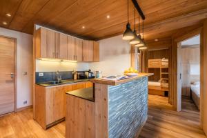 una cucina con mobili in legno e un piano di lavoro di Apartment Itauba Courchevel 1850 - by EMERALD STAY a Courchevel Altre 16 foto