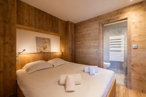 una camera da letto con un letto con due asciugamani sopra di Apartment Itauba Courchevel 1850 - by EMERALD STAY a Courchevel