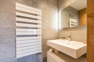 un bagno con lavandino e specchio di Apartment Itauba Courchevel 1850 - by EMERALD STAY a Courchevel