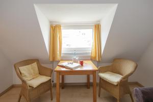 einen kleinen Tisch mit zwei Stühlen und einem Fenster in der Unterkunft Ferienanlage Duhnen in Cuxhaven