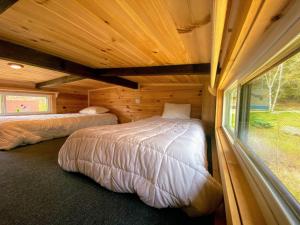 a bedroom with two beds in a wooden cabin at B11 NEW Awesome Tiny Home with AC Mountain Views Minutes to Skiing Hiking Attractions in Carroll