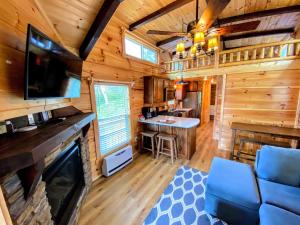 uma sala de estar com televisão e um bar numa cabana de madeira em B2 NEW Awesome Tiny Home with AC Mountain Views Minutes to Skiing Hiking Attractions em Carroll