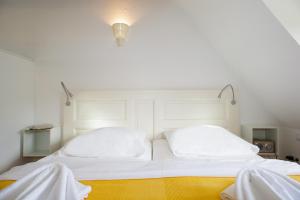Una cama blanca con dos almohadas encima. en Ferienanlage Duhnen, en Cuxhaven