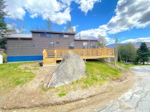 CarrollB2 NEW Awesome Tiny Home with AC Mountain Views Minutes to Skiing Hiking Attractions的一座带木甲板和大岩石的房子