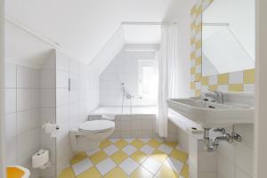 Baño blanco con lavabo y aseo en Ferienanlage Duhnen, en Cuxhaven