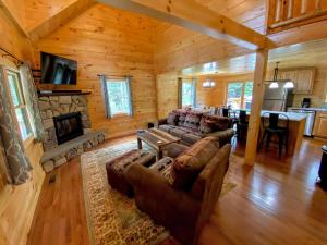 a living room with a couch and a fireplace at Brand New Log Home Well appointed great location with AC wifi cable fireplace firepit in Bethlehem