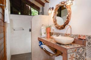 a bathroom with a sink and a mirror at Villas El Encanto Cozumel in Cozumel