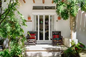 a door leading to a patio area with chairs and tables at Villas El Encanto Cozumel in Cozumel