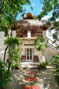 a large white house with trees and bushes at Villas El Encanto Cozumel in Cozumel