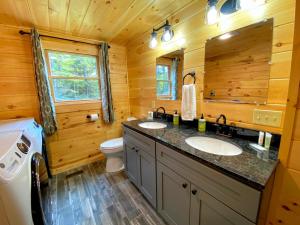Cabaña de madera con baño con 2 lavabos y aseo en Brand New Log Home Well appointed great location with AC wifi cable fireplace firepit, en Bethlehem