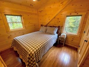 a bedroom with a bed in a log cabin at Brand New Log Home Well appointed great location with AC wifi cable fireplace firepit in Bethlehem