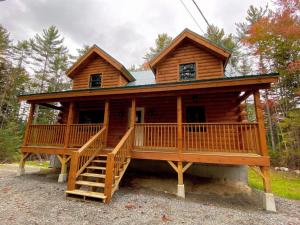 una grande baita di tronchi con un ampio ponte di Brand New Log Home Well appointed great location with AC wifi cable fireplace firepit a Bethlehem