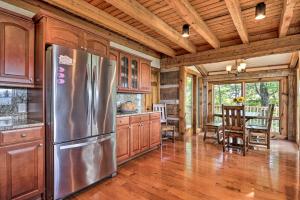 a kitchen with wooden cabinets and a stainless steel refrigerator at Upscale Gatlinburg Cabin Deck, Fire Pit and Hot Tub in Gatlinburg