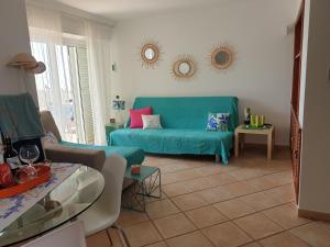 Bungalow Paraiso El Mar 3 في سان أغوستِن: غرفة معيشة مع أريكة زرقاء وطاولة