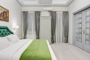 a bedroom with a bed and a dresser at Pandrosos Divine Suites in Athens