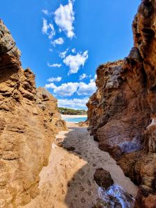a view of a beach between two rocks at Rigat Park & Spa Hotel - Adults Recommended in Lloret de Mar