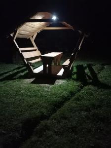 ein Picknicktisch im Gras bei Nacht in der Unterkunft Cabanute Luca Ama Bran in Braşov