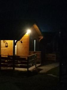 une cabine avec une lumière sur son côté la nuit dans l'établissement Cabanute Luca Ama Bran, à Braşov