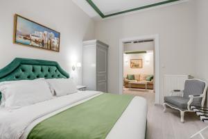sypialnia z dużym łóżkiem z zielonym zagłówkiem w obiekcie Pandrosos Divine Suites w Atenach