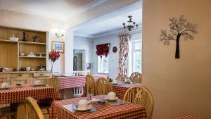 a dining room with two tables with red and white tablecloths at Pickwicks Guest House in Oxford