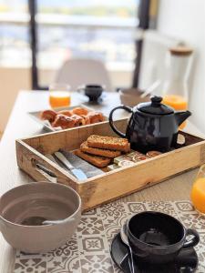 a table with a tray of food and a tea kettle at Appartement secteur gare avec balcon et vue panoramique in Chambéry