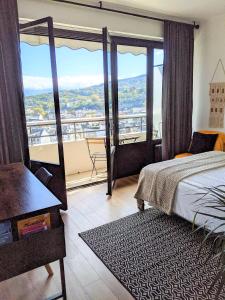 um quarto com uma cama e uma varanda com vista em Appartement secteur gare avec balcon et vue panoramique em Chambéry