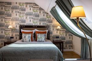 een slaapkamer met een bed en een muur met gebouwen bij Hôtel Le 46 in Parijs