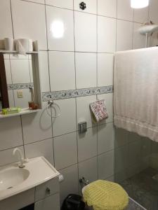 a bathroom with a sink and a toilet and a mirror at Residencial Marcelino in Porto Belo +16 photos
