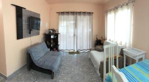 a living room with a bed and a chair and a couch at Residencial Marcelino in Porto Belo