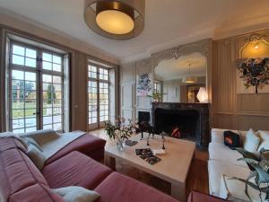 a living room with a couch and a fireplace at Le domaine de barbizon by Quartz investissements in Saint-Martin-en-Bière