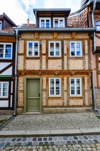 ein Haus mit einer grünen Garage davor in der Unterkunft Kramerstube in Quedlinburg