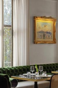 a dining room with a green couch and a table at La Colombe d'Or Hotel in Houston