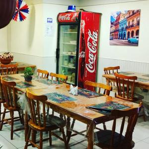 una sala da pranzo con tavolo e una macchina da coca-cola di Hostal Del Tuto a Punta Arenas