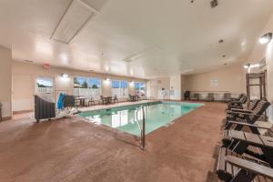 Una piscina en una habitación grande con sillas y mesas. en Quality Inn & Suites Hendersonville - Flat Rock, en Flat Rock