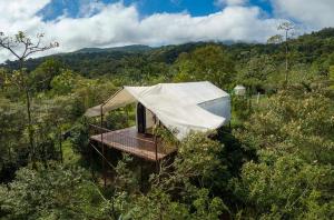 a luxury tent in the middle of a forest at Garza del Sol Glamping Río Celeste Buganvilia in San Rafael