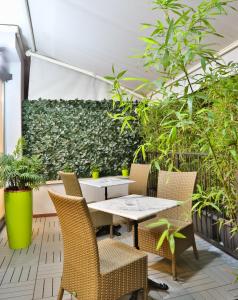 une table et des chaises sur une terrasse agrémentée de plantes dans l'établissement Hotel Astoria Sure Hotel Collection By Best Western, à Milan