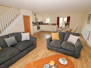 a living room with two couches and a table at Rose Cottage in Stratford-upon-Avon