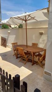 a wooden table and chairs with an umbrella at Casa Roberto Beach in Torvaianica