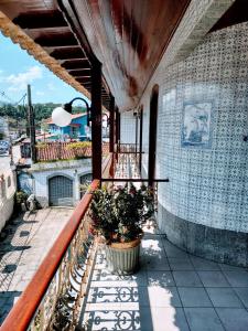 a balcony with a potted plant on a building at Pousada Caravelas - Centro de Paraty in Paraty