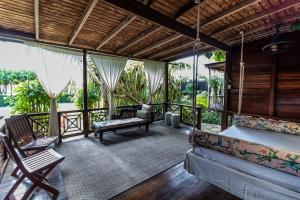 a screened in porch with a couch and a chair at Sweetfield Manor in Bridgetown