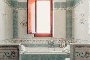 uma casa de banho com uma banheira e uma janela em B&B Elvira Al Duomo em Monreale