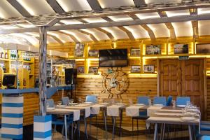 a dining room with tables and chairs and a flat screen tv at Mini hotel Gavan Nadiezhdy in Zhukovsky