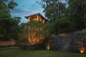 a house with a stone wall and stairs at Green Escape Unawatuna in Unawatuna