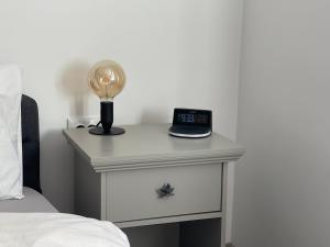 a bedside table with a clock on top of it at Maple Lodge Apartments in Braşov