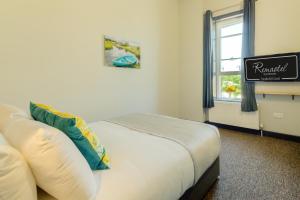 a bedroom with a bed and a window and a sign at Remaotel Seafield Court Apartments in Great Yarmouth