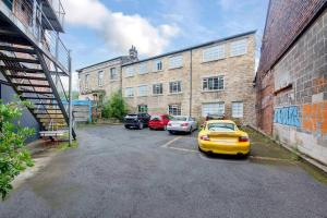 a parking lot with cars parked in front of a building at Lovely Central 1 Bed Apartment Sleeps 4 in Sheffield