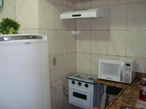 uma pequena cozinha com fogão e micro-ondas em Apart Marcelo - Studio Copacabana no Rio de Janeiro