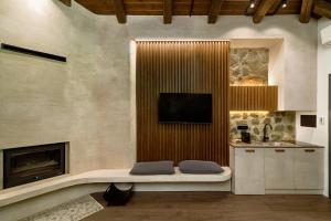 a living room with a tv and a fireplace at Bocca al Lupo Villas in Kato Loutraki